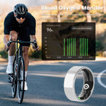 Person cycling with a blood oxygen monitor display and a blood oxygen sensor on a road.
