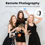 Three women in formal attire celebrating with champagne, using a smartphone and remote photography device.