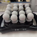 Device with multiple white balls on a desk with a keyboard in the background