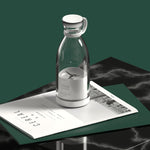 Clear glass carafe with white base on a dark marble surface with a magazine underneath