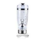 Clear blender bottle with measurement markings and USB cable on a white background
