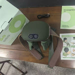 Green massage device with accessories on a wooden table